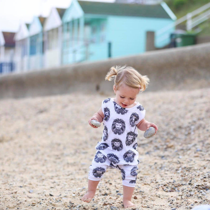 Toddler girl wearing Lottie & Lysh aztec lion tankie romper on a beach