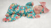 Close up of a sweet newborn baby girl wearing a lottie and lysh cherubs print babygrow with matching bow turban headwrap