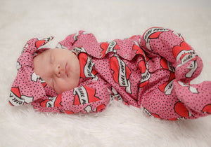 Pink baby girl babygrow with integrated mitts and feet. Worn by a sleeping newborn baby girl with a matching headband.