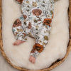A close up image of a baby laying in a wicker basket. The baby is wearing a Lottie & Lysh floral footless romper which has been ethically and sustainably produced by Lottie & Lysh