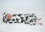 newborn baby girl wearing a bow print baby romper with matching headband by Lottie & Lysh