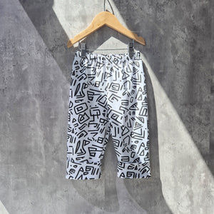 Mono90s baby trousers laid flat showing bold abstract print and relaxed fit, made with Oeko Tex certified jersey fabric