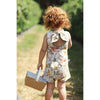 red haired little girl in a strawberry field wearing a vintage inspired floral playsuit by Lottie & Lysh