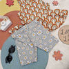 Lottie & lysh flat lay image featuring a rainbow print peplum bottom vest and daisy print cycling shorts.