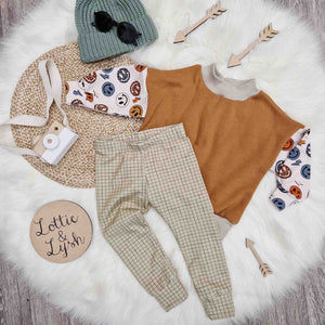 Kids outfit flat lay image featuring Lottie & lysh sage grid leggings, retro smiley oversized sweatshirt and green knitted beanie hat