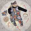 christmas print baby and toddler dungarees featuring black and white background with hipster santa elements. Photographed with a matching headband and bib