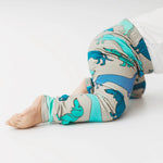 Baby wearing grey leggings with blue and green sausage dog print. Handmade in the Uk by Lottie & Lysh. 