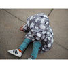 small boy sitting on the floor wearing lottie and lysh penguin raincoat and rhino leggings