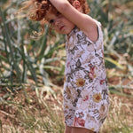 little girl wearing a floral short playsuit made by Lottie & Lysh